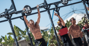 male crossfitters doing pull ups outdoors