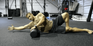 male crossfit athlete foam rolling