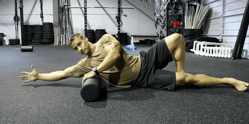 male crossfit athlete foam rolling