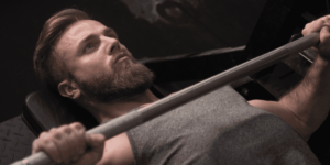 male freeletics athlete bench pressing through training plateau