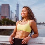 woman smiles in fitness gear with abs muscles