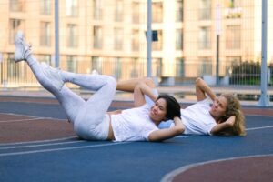 two women practice crunch variations for abs