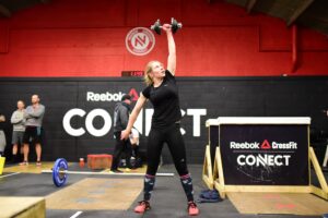 crossfit community member performs dumbbell snatch