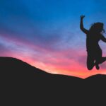 learn how to fix your circadian rhythm like this woman who is jumping into the sunset full of energy