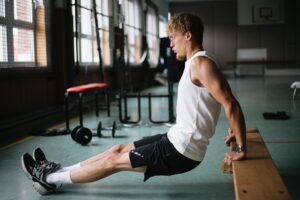 athlete trains his triceps muscles with dips How to Get Bigger Triceps
