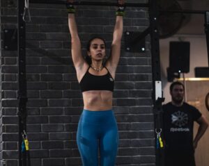 athlete hangs from barbell