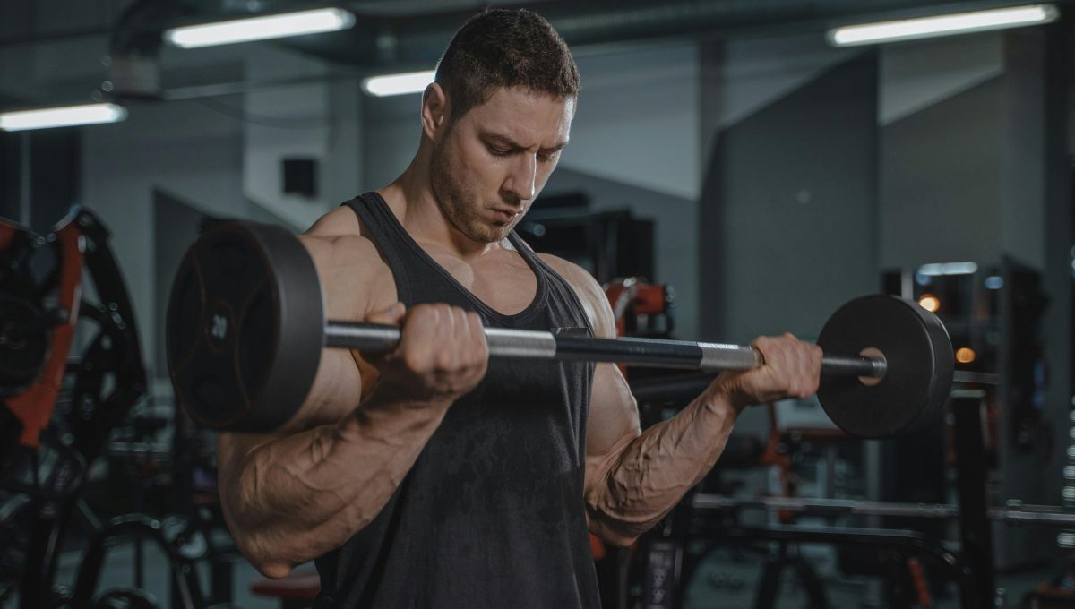man in gym doing a barbell curl