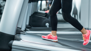 Athlete performing treadmill incline walking workout in gym to burn fat and build endurance